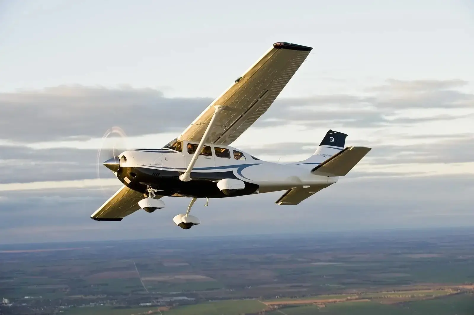 Light charter aircraft in flight over farmland