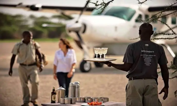 Guests greeted with drinks beside a Cessna Caravan on a bush airstrip